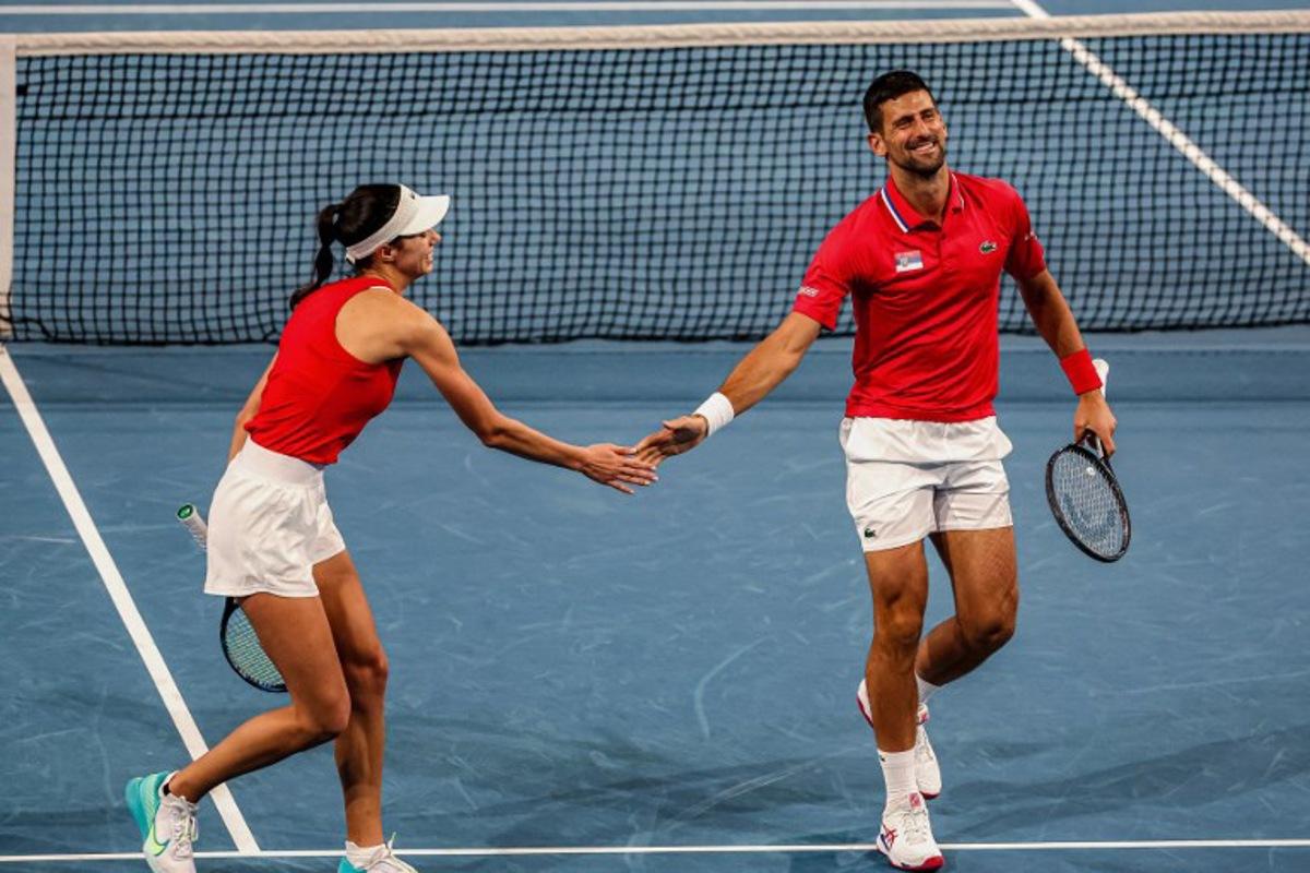 Serbia's Olga Danilovic and Novak Djokovic (R) greet each other while playing against China's Qinwen Zheng and Zhang Zhizhen during their doubles match at the United Cup tennis tournament in Perth on December 31, 2023. COLIN MURTY / AFP