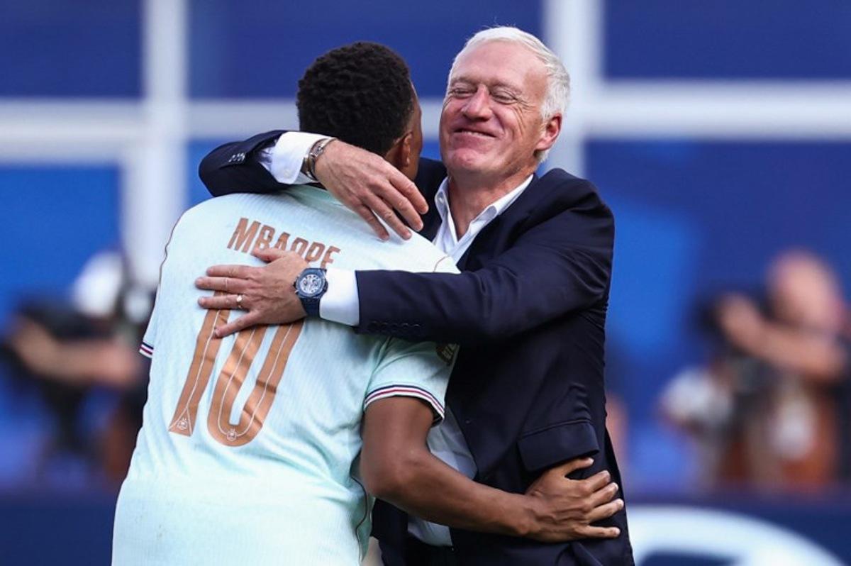 France's forward #10 Kylian Mbappe and head coach Didier Deschamps hug after winning the 2026 World Cup football tournament quarter-final match between France and Morocco at Boston Stadium in Foxborough on July 9, 2026. FRANCK FIFE / AFP