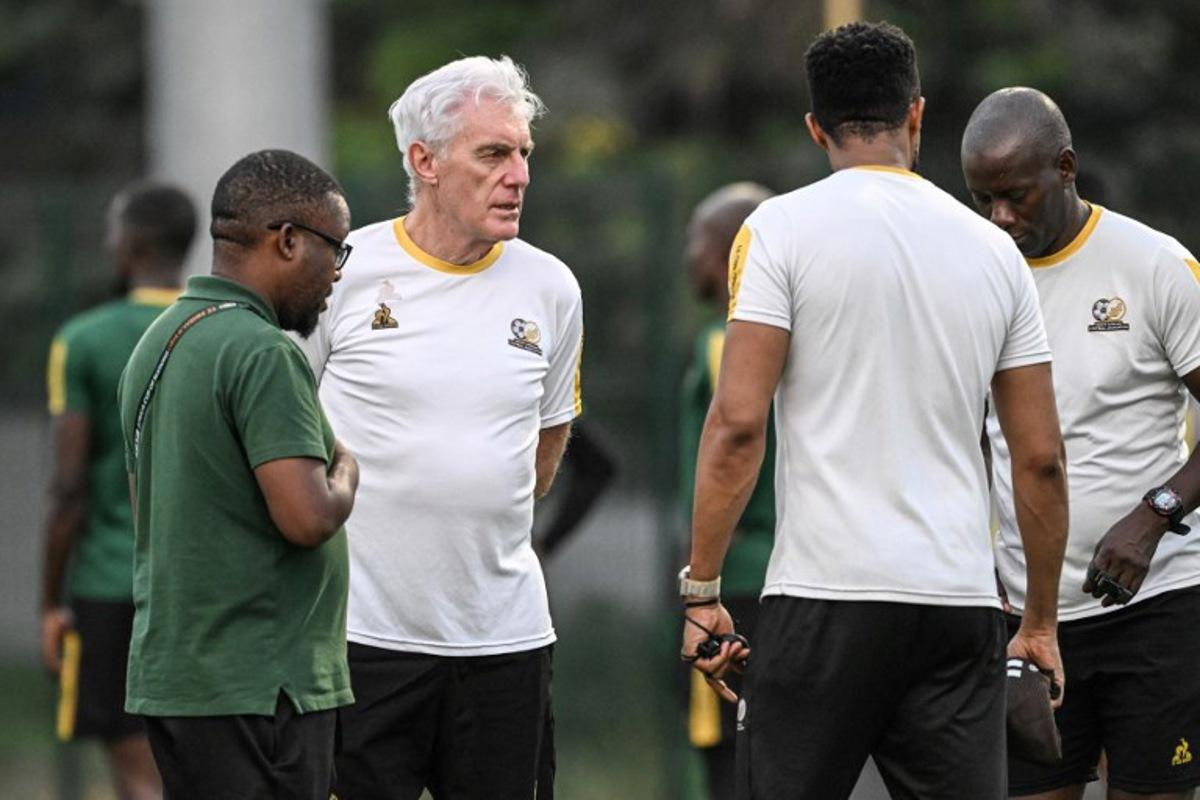 South Africa's headcoach Hugo Broos (C) speaks to South Africa's players as they attend a training session at the Lycee Classique stadium in Abidjan on February 9, 2024, on the eve of the 2024 African Cup of Nations (CAN) football match between South Africa and DR Congo for third place. Sia KAMBOU / AFP