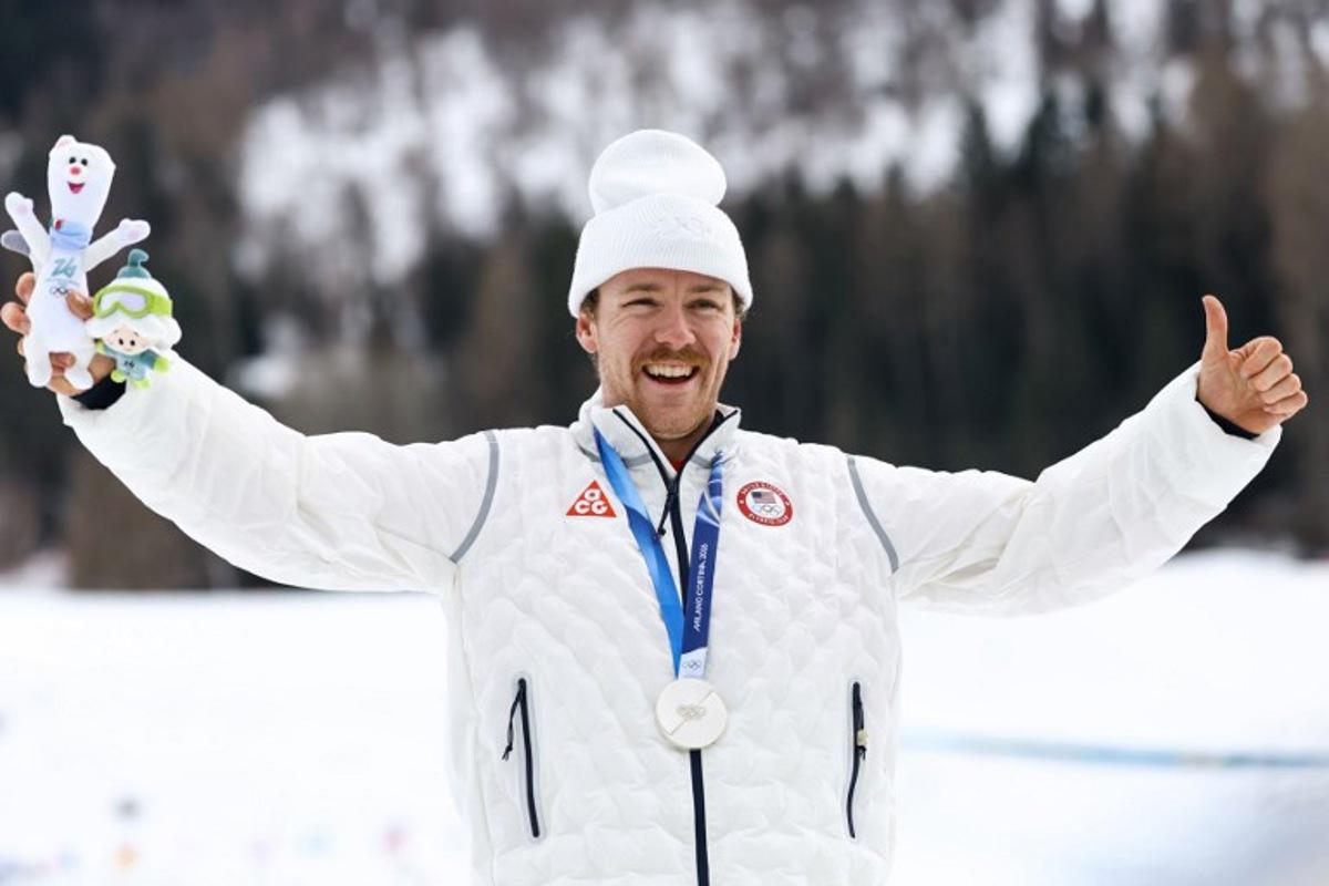 Silver medallist USA's Ben Ogden celebrates on the podium for the men's cross country sprint classic final event of the Milano Cortina 2026 Winter Olympic Games at Tesero Cross-Country Skiing Stadium in Lago di Tesero (Val di Fiemme), on February 10, 2026. Anne-Christine POUJOULAT / AFP