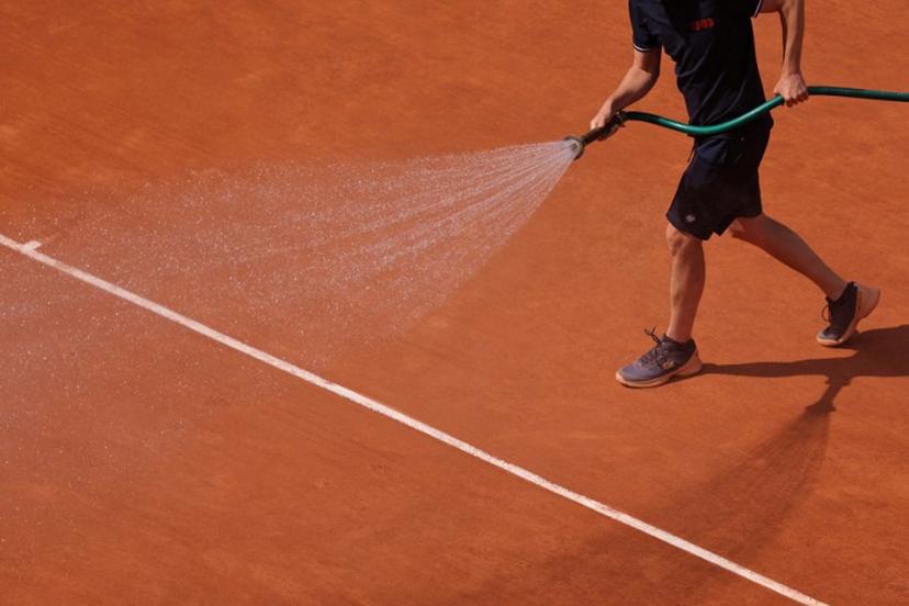 An employee sprays water on the clay during their men's singles quarter final match between Serbia's Novak Djokovic and Russia's Karen Khachanov on day ten of the Roland-Garros Open tennis tournament at the Court Philippe-Chatrier in Paris on June 6, 2023. Thomas SAMSON / AFP