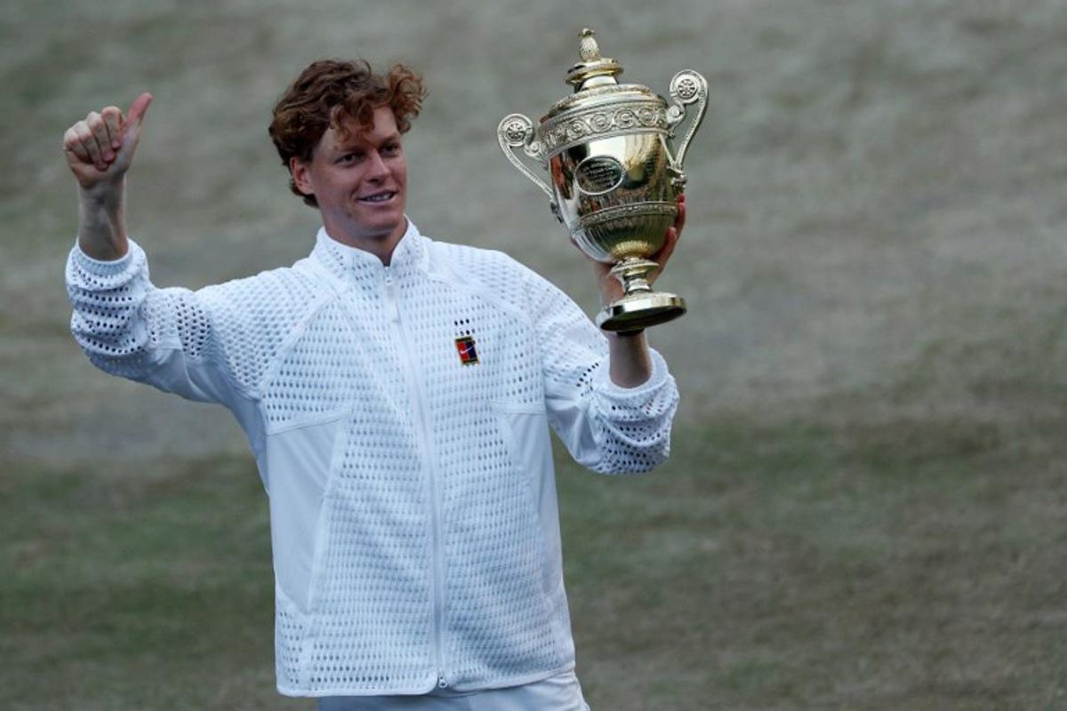 Italy's Jannik Sinner poses with his trophy after beating Germany's Alexander Zverev during their men's singles final tennis match on the fourteenth day of the 2026 Wimbledon Championships at The All England Lawn Tennis and Croquet Club in Wimbledon, southwest London, on July 12, 2026. Adrian Dennis / AFP