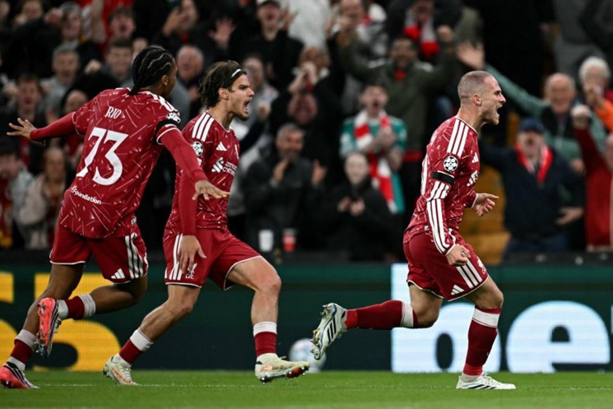 Liverpool's Argentinian midfielder #10 Alexis Mac Allister (R) celebrates scoring the team's second goal during the UEFA Champions League football match between Liverpool and Atletico Madrid at Anfield in Liverpool, north west England on September 9, 2026. Paul ELLIS / AFP