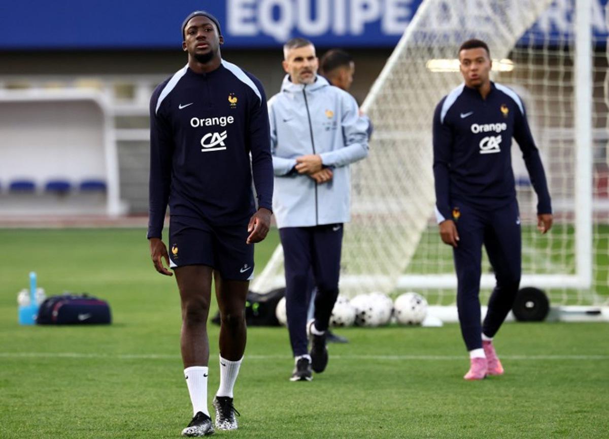 France's defender #24 Ibrahima Konate (L) and France's forward #10 Kylian Mbappe (R) react after stopping his training next to France's physical trainer Cyril Moine (C) as part preparations for upcoming FIFA World Cup 2026 Group D European qualification football matches, at the team's training grounds in Clairefontaine-en-Yvelines, southwest of Paris, on October 8, 2025. France will face Azerbaidjan on October 10 and Iceland on October 13. FRANCK FIFE / AFP