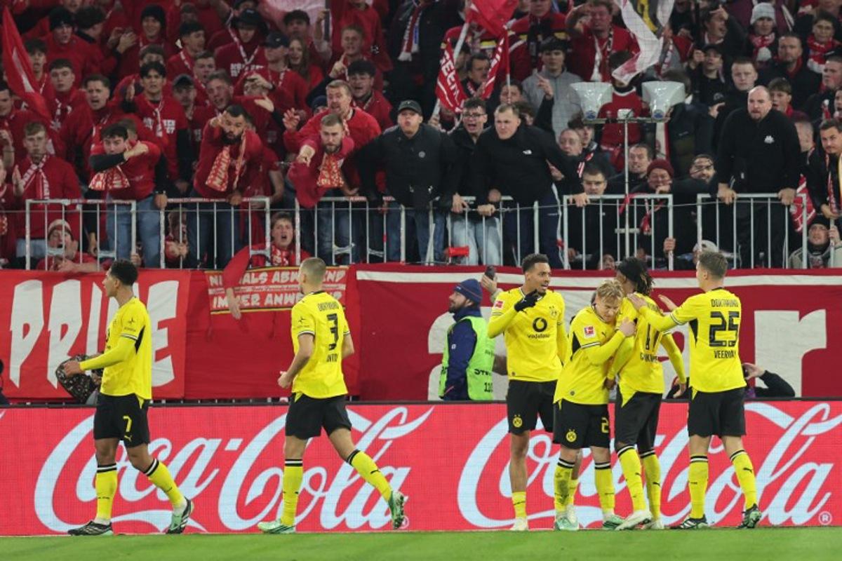 Dortmund's English midfielder #07 Jobe Bellingham (L) celebrates scoring with his teammates before the goal was disallowed for offside by VAR during the German first division Bundesliga football match between FC Bayern Munich and BVB Borussia Dortmund in Munich, southern Germany, on October 31, 2026. Alexandra BEIER / AFP