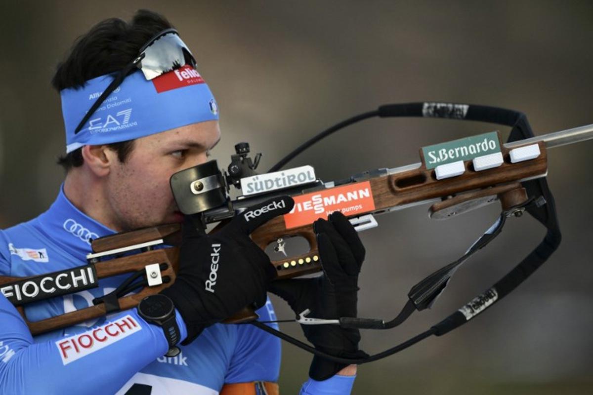 Italy's Tommaso Giacomel reacts as he competes during the men's 15km mass start event of the IBU Biathlon World Cup, in Le Grand Bornand, near Annecy, southeastern France, on December 21, 2025. Olivier CHASSIGNOLE / AFP