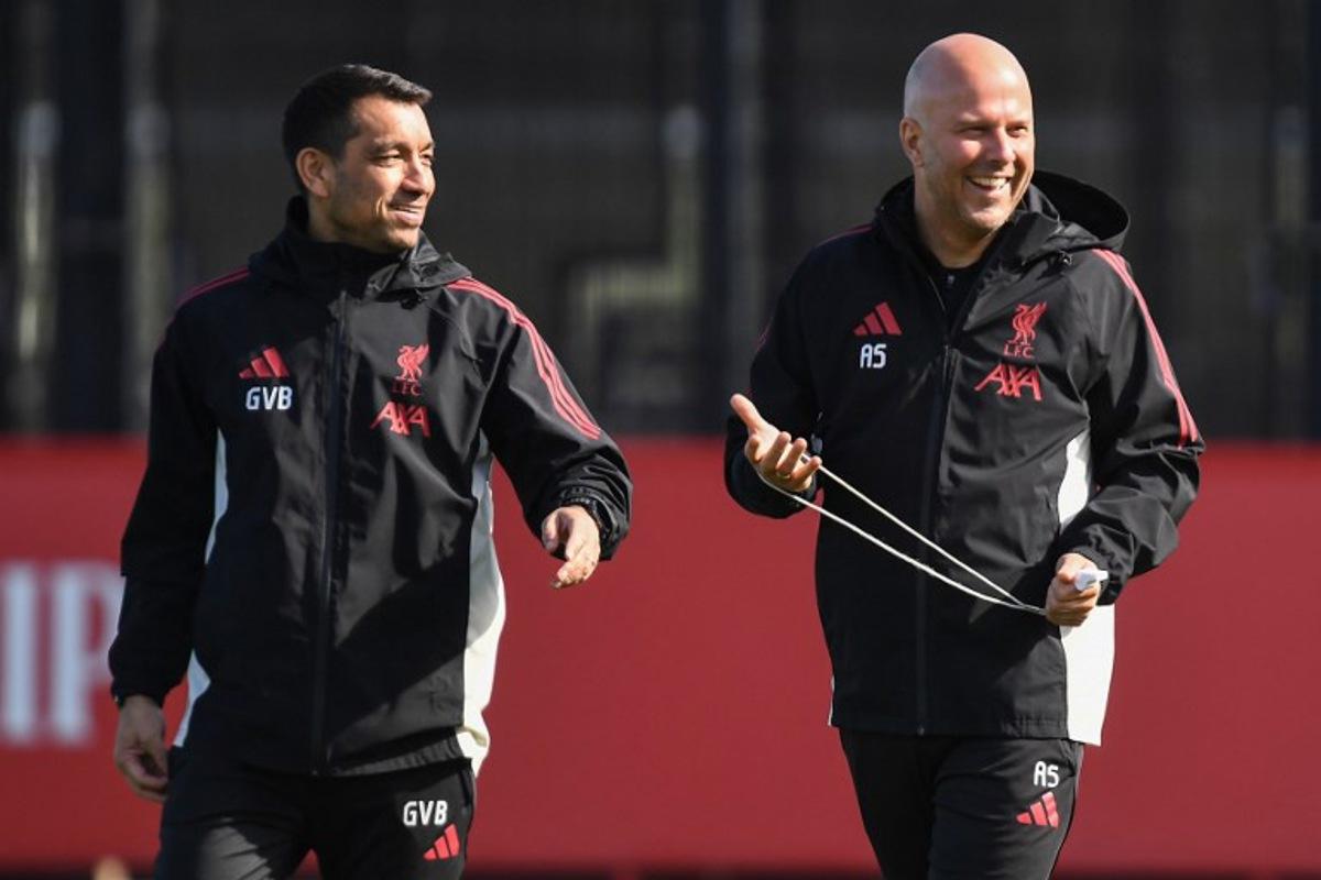 Liverpool's Dutch manager Arne Slot (R) Liverpool's Dutch Assistant Manager and Giovanni van Bronckhorst smile during a team training session at their training ground in Kirkby, Liverpool, north-west England on March 17, 2026, on the eve of their UEFA Champions League, last 16 second leg football match against Galatasaray. PETER POWELL / AFP