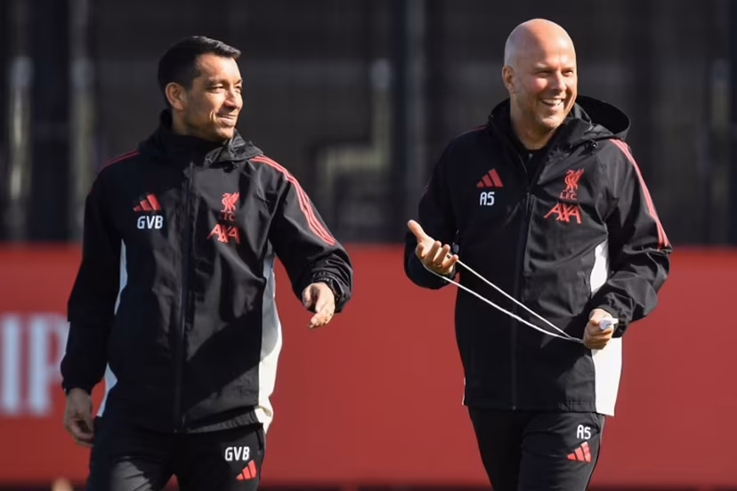 Liverpool's Dutch manager Arne Slot (R) Liverpool's Dutch Assistant Manager and Giovanni van Bronckhorst smile during a team training session at their training ground in Kirkby, Liverpool, north-west England on March 17, 2026, on the eve of their UEFA Champions League, last 16 second leg football match against Galatasaray. PETER POWELL / AFP