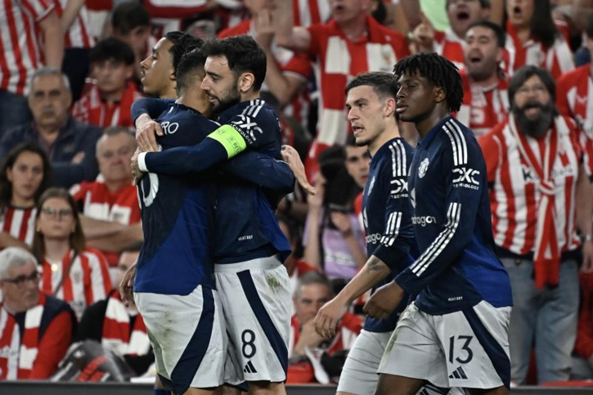 Manchester United's Portuguese midfielder #08 Bruno Fernandes celebrates with teammates after scoring their second goal during the UEFA Europa League semi final first leg football match between Athletic Club Bilbao and Manchester United at the San Mames stadium in Bilbao, on May 1, 2025. ANDER GILLENEA / AFP