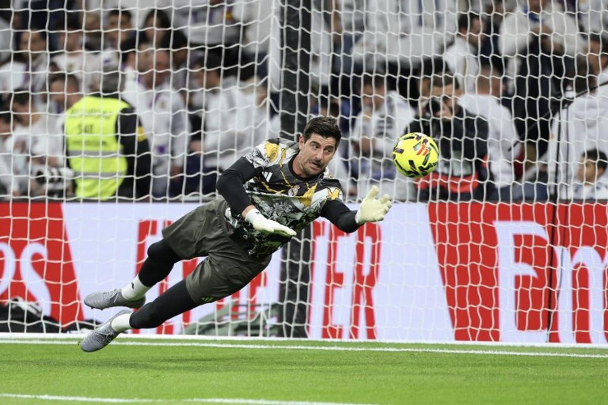 Real Madrid's Belgian goalkeeper #01 Thibaut Courtois warms up before the start of the Spanish league football match between Real Madrid CF and RC Celta de Vigo at the Santiago Bernabeu Stadium in Madrid on December 7, 2025. Thomas COEX / AFP