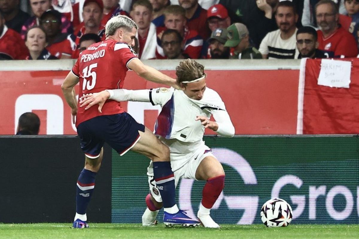 PSG's Belgian forward #22 Mika Godts (R) and Lille's French defender #15 Romain Perraud fight for the ball during the French L1 football match between Lille LOSC and Paris Saint-Germain (PSG) at the Stade Pierre-Mauroy in Villeneuve-d'Ascq, northern France, on August 28, 2026. Sameer AL-DOUMY / AFP
