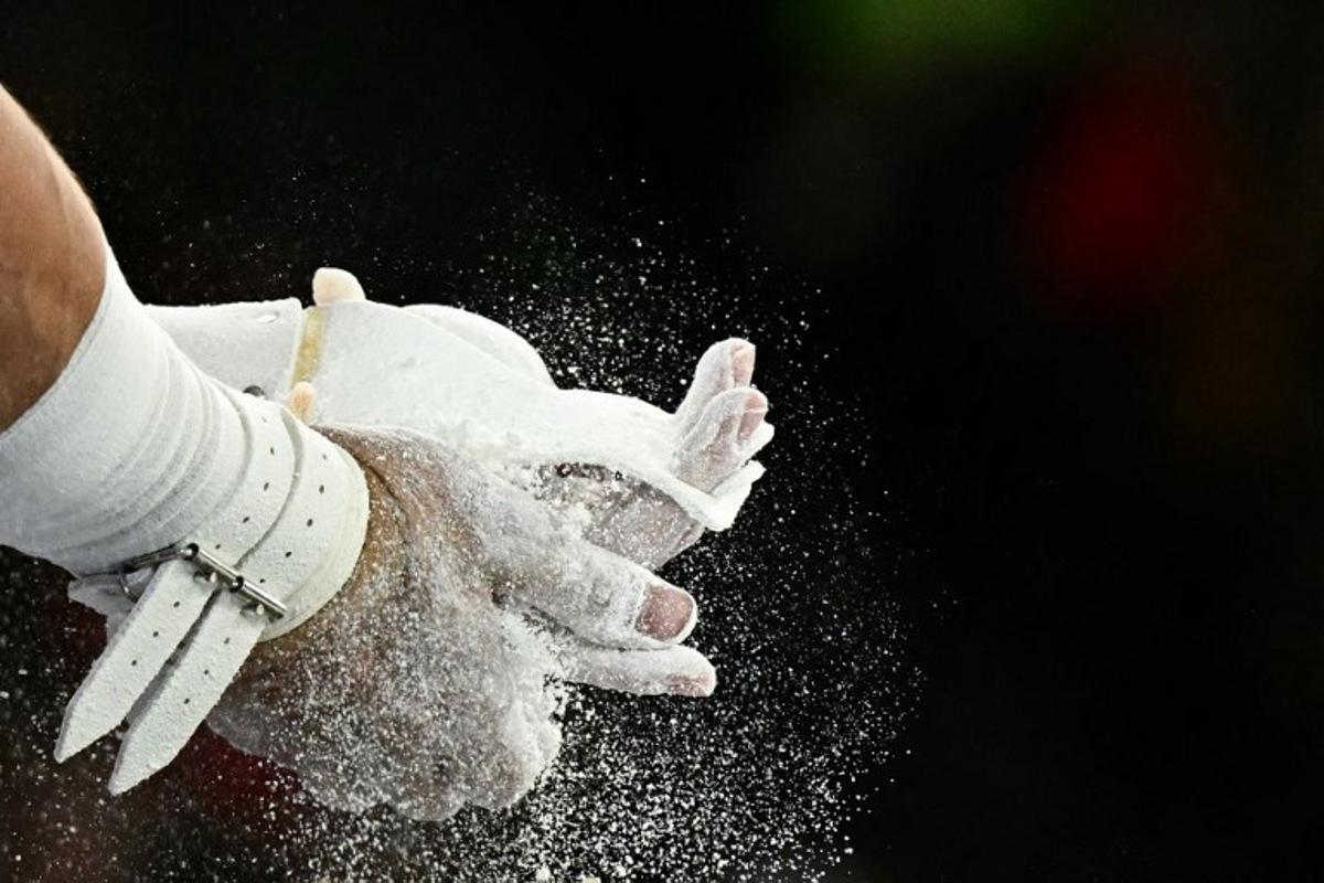 US' Brody Malone puts chalk on his hands before competing in the horizontal bar event of the artistic gymnastics men's qualification during the Paris 2024 Olympic Games at the Bercy Arena in Paris, on July 27, 2024. Gabriel BOUYS / AFP