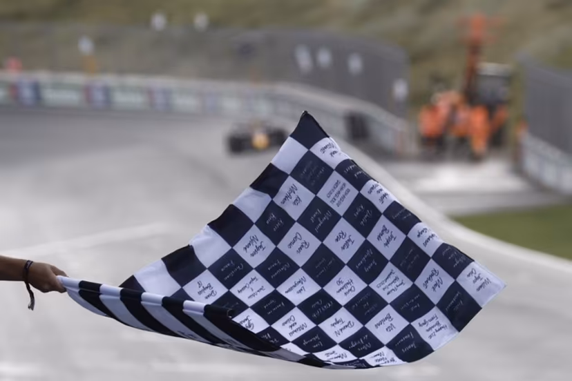 A person waves a finish flag as Red Bull Racing's Dutch driver Max Verstappen drives to win the Dutch Formula One Grand Prix race at The Circuit Zandvoort, in Zandvoort on August 27, 2023. SIMON WOHLFAHRT / POOL / AFP