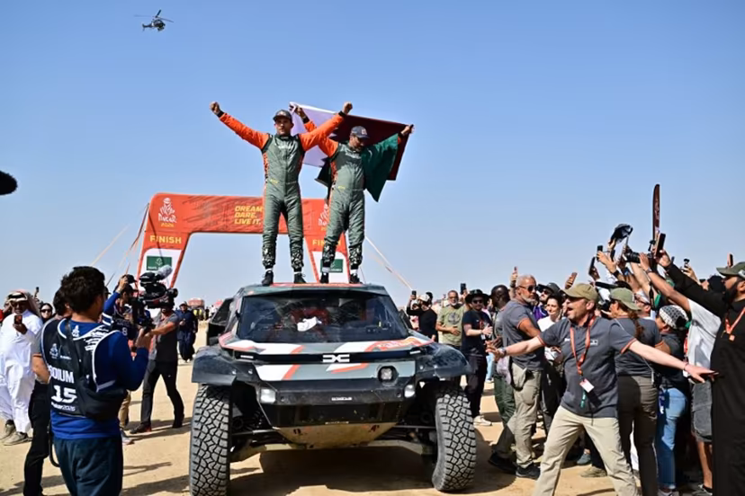 The Dacia Sandriders' Qatari driver Nasser al-Attiyah (R) and Belgian copilot Fabian Lurquin celebrate after winning the 48th edition of the Dakar Rally 2026 in Yanbu, Saudi Arabia, on January 17, 2026. Qatar's Nasser Al-Attiyah secured his sixth Dakar Rally car title in Saudi Arabia. Giuseppe CACACE / AFP