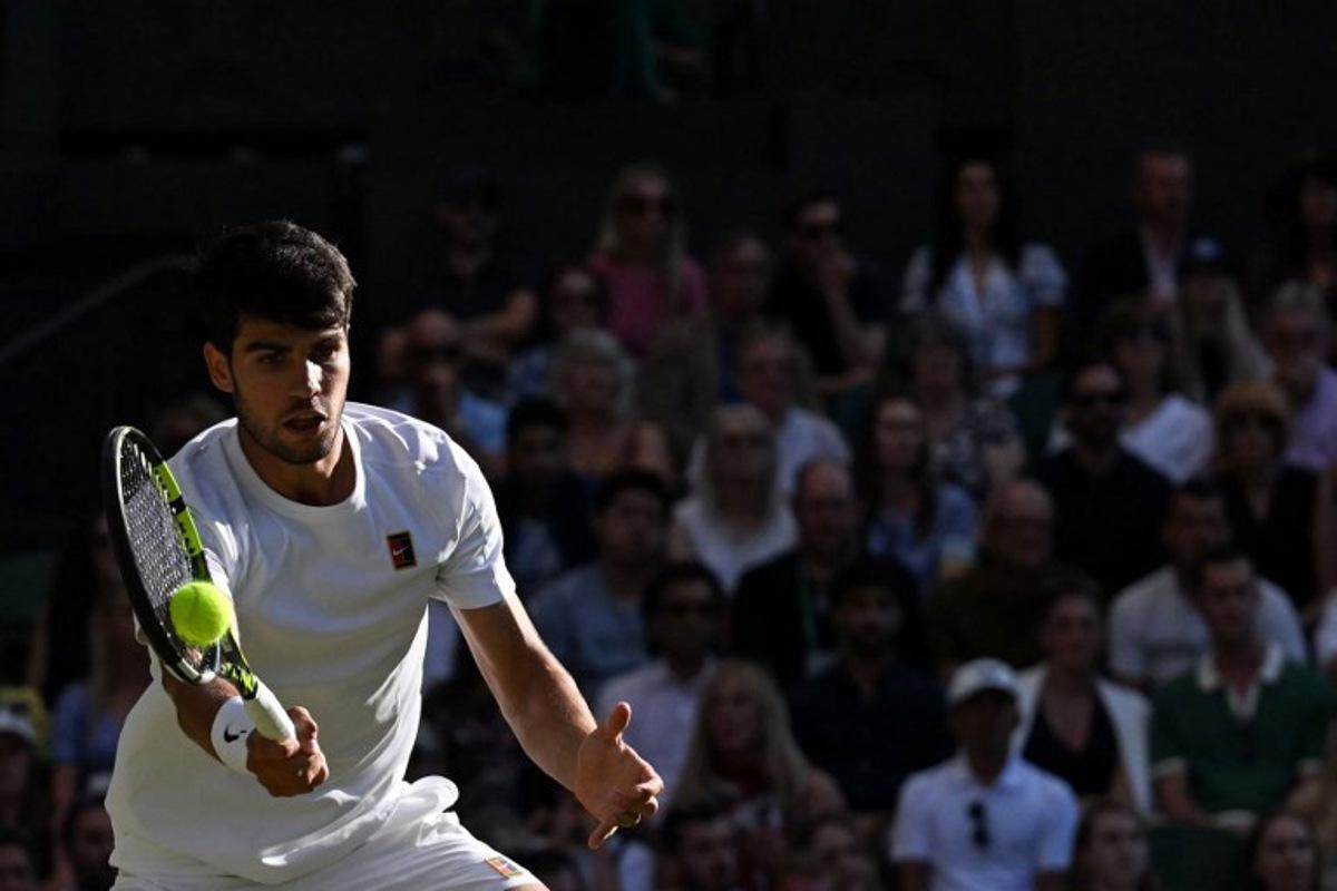 Spain's Carlos Alcaraz plays a forehand return to Britain's Cameron Norrie during their men's singles quarter-final tennis match on the ninth day of the 2025 Wimbledon Championships at The All England Lawn Tennis and Croquet Club in Wimbledon, southwest London, on July 8, 2025. Glyn KIRK / AFP