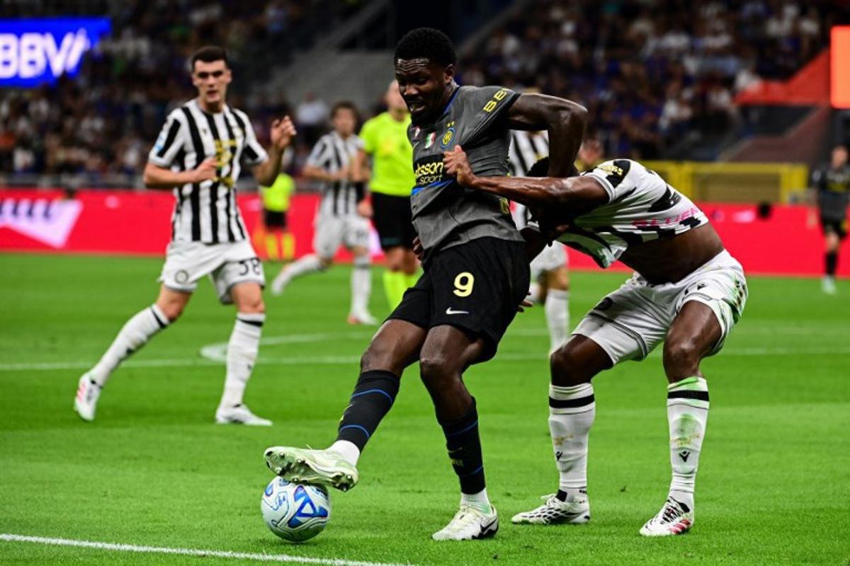Inter Milan's French forward #09 Marcus Thuram fights for the ball with Udinese's Belgian defender #27 Christian Kabasele during the Italian Serie A football match between Inter Milan and Udinese at the San Siro Stadium in Milan, Italy on September 14, 2026. Piero CRUCIATTI / AFP