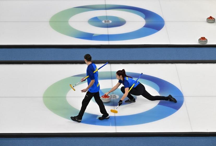Ukraine's Marharyta Lytvynenko (R) and Artem Shlyk (L) compete against Qatar in the curling mixed doubles round robin session 14 during the Gangwon 2024 Winter Youth Olympic Games at Gangneung Curling Centre in Gangneung on January 31, 2024. Jung Yeon-je / AFP