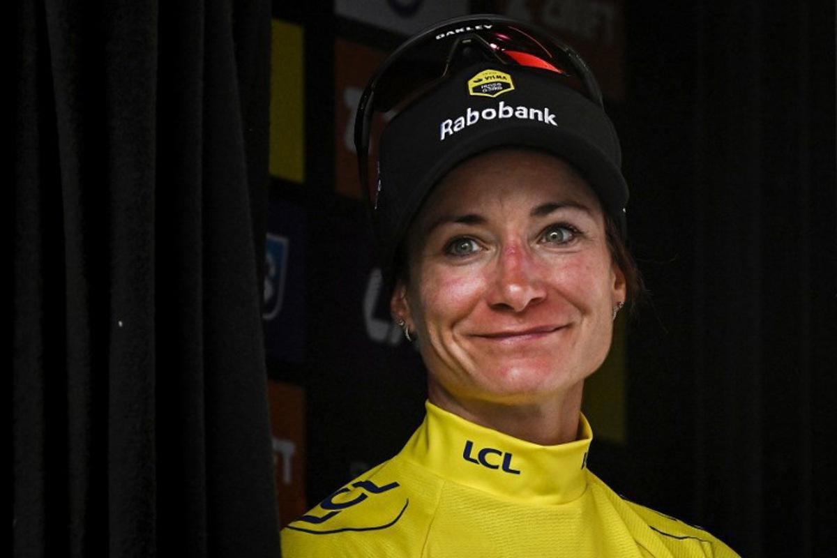 Team Visma | Lease a Bike's Dutch rider Marianne Vos celebrates on the podium with the overall leader's yellow jersey after the 3rd stage (out of 9) of the fourth edition of the Women's Tour de France cycling race, 163.5 km from La Gacilly to Angers, in Angers, western France on July 28, 2025. JULIEN DE ROSA / AFP