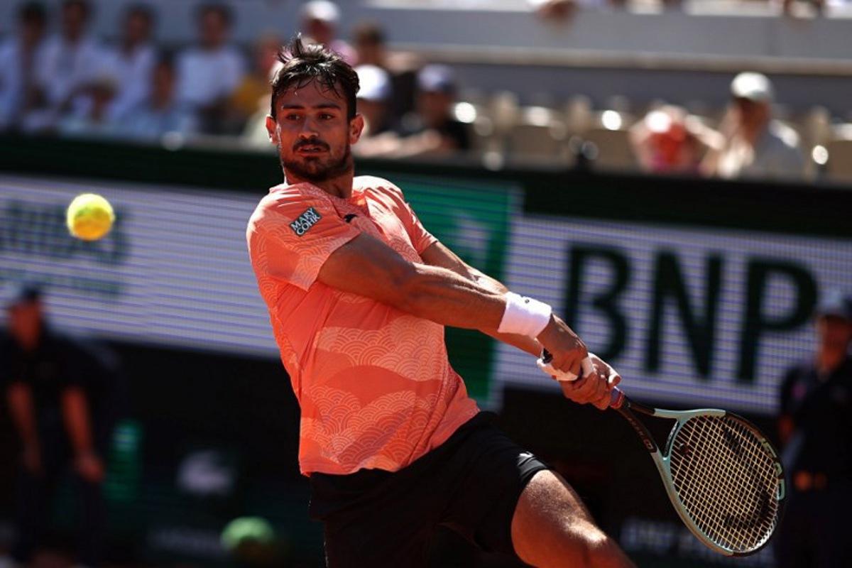 Argentina's Mariano Navone plays a backhand return to Italy's Lorenzo Musetti during their men's singles match on day 6 of the French Open tennis tournament on Court Suzanne-Lenglen at the Roland-Garros Complex in Paris on May 30, 2025. Anne-Christine POUJOULAT / AFP