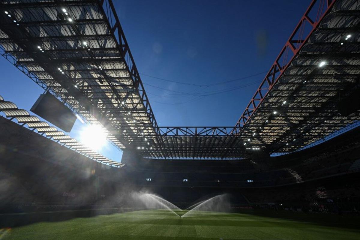 Sprinklers spray water on the pitch ahead of the Italian Serie A football match between AC Milan and Sassuolo at the San Siro Stadium in Milan, Italy on December 14, 2025. Piero CRUCIATTI / AFP