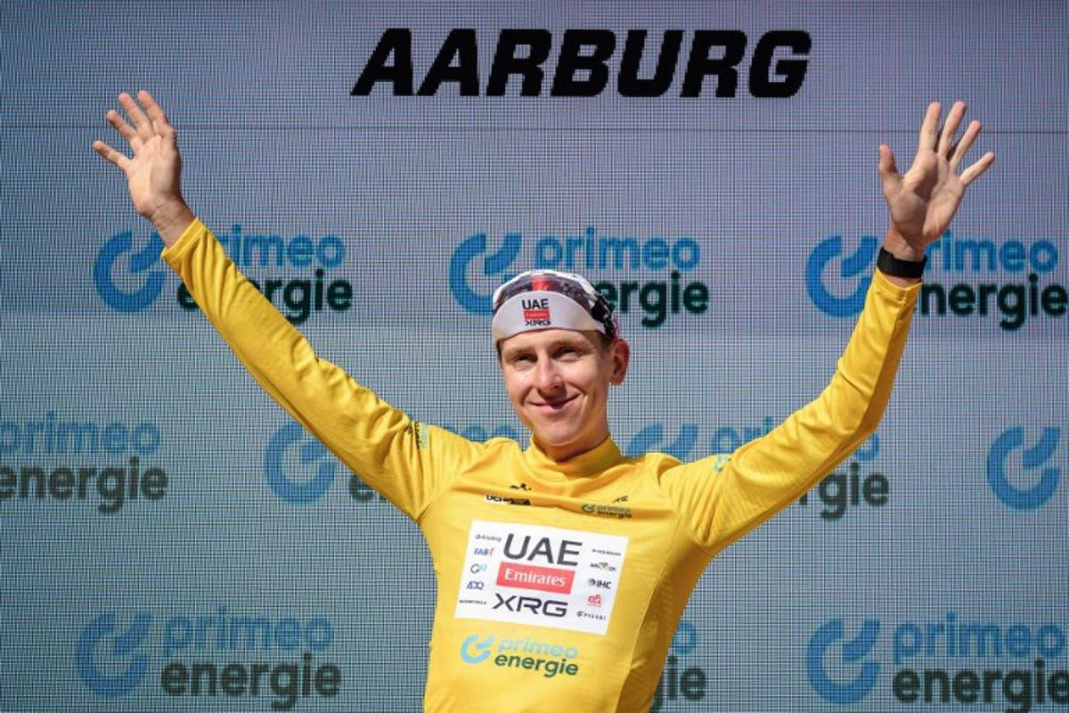 UAE Team Emirates-XRG's Slovenian rider Tadej Pogacar wearing the overall leader's yellow jersey celebrates on the podium of the fourth stage, a 23.7 km time trial from Aarburg to Aarburg, at the Men's Tour of Switzerland (Tour de Suisse) cycling race in Aarburg, Switzerland, on June 20, 2026. Fabrice COFFRINI / AFP