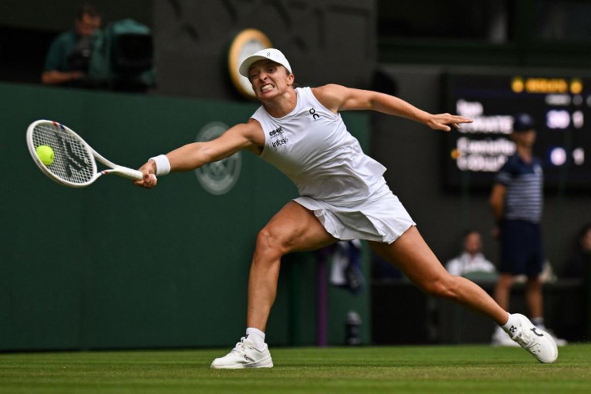 Poland's Iga Swiatek plays a forehand return to US player Danielle Collins during their women's singles third round tennis match on the sixth day of the 2025 Wimbledon Championships at The All England Lawn Tennis and Croquet Club in Wimbledon, southwest London, on July 5, 2025. Glyn KIRK / AFP