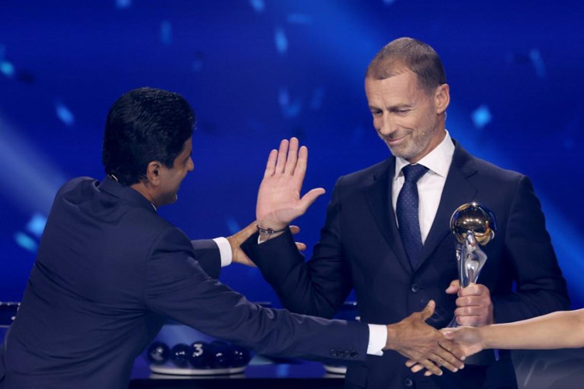 Paris Saint Germain's Qatari president Nasser al-Khelaifi (L) receives UEFA Respect Award from UEFA President Aleksander Ceferin during the draw ceremony for the league phase of the 2026-2027 UEFA Champions League football tournament at the Grimaldi Forum in the Principality of Monaco on August 27, 2026. Valery HACHE / AFP