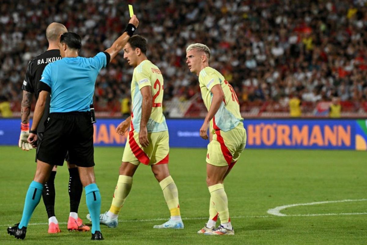 Dutch referee Serdar Gozubuyuk (2-R) gives a yellow card to Spain's forward #10 Dani Olmo (R) during the UEFA Nations League Group A4 football match between Serbia and Spain at the Rajko-Mitic stadium in Belgrade on September 5, 2024. Andrej ISAKOVIC / AFP