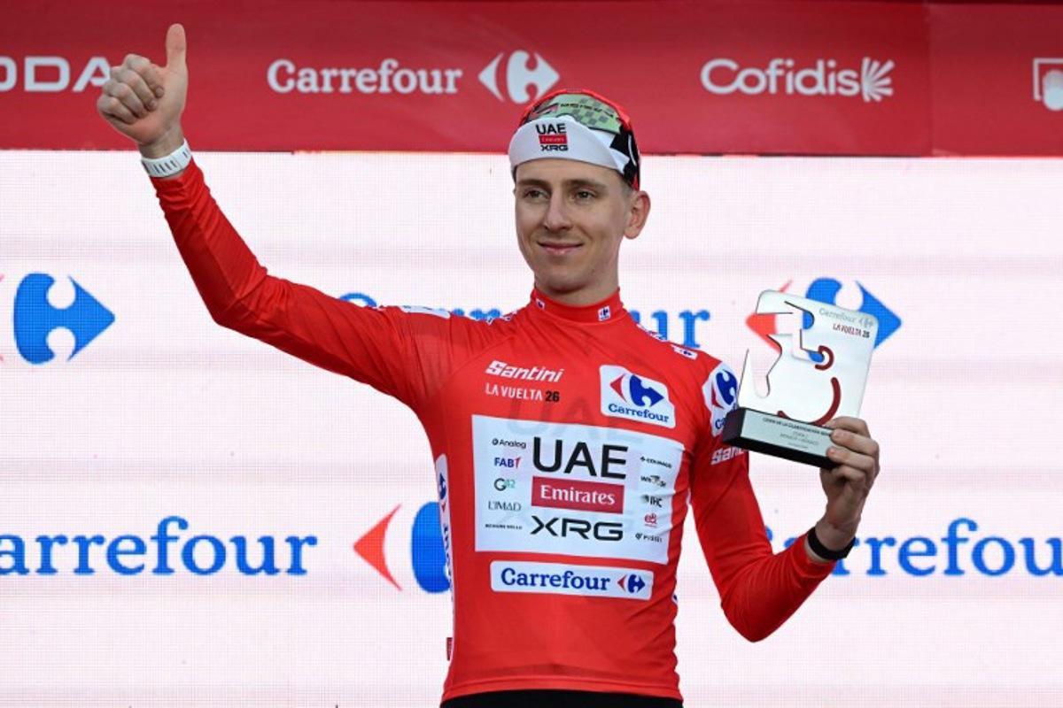 UAE Team Emirates - XRG team's Slovenian rider Tadej Pogacar celebrates on the podium wearing the overall leader's red jersey, after winning the first stage of the Vuelta a Espana 2026, a 9,4 km time-trial between Monaco and Monaco on August 22, 2026. Miguel MEDINA / AFP