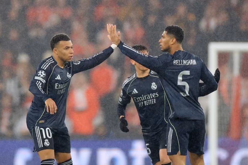 Real Madrid's French forward #10 Kylian Mbappe (L) celebrates after scoring his team's second goal with teammate English midfielder #05 Jude Bellingham (R) during the UEFA Champions League league phase day 8 football match between SL Benfica and Real Madrid CF at Estadio da Luz in Lisbon on January 28, 2026. PATRICIA DE MELO MOREIRA / AFP