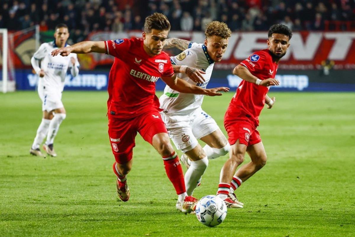 PSV's Dutch forward #07 Noa lang (C) fights for the ball with FC Twente's Dutch defender #28 Bart van Rooij (2L) during the Dutch Eredivisie football match between FC Twente and PSV Eindhoven at the Stadion De Grolsch Veste, in Enschede, on April 24, 2025. Vincent Jannink / ANP / AFP