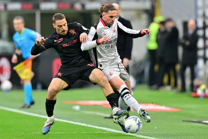 Torino's Croatian midfielder #10 Nikola Vlasic fights for the ball with AC Milan's French midfielder #12 Adrien Rabiot (R) during the Italian Serie A football match between AC Milan and Torino at San Siro stadium in Milan, northern Italy, on March 21, 2026. Stefano RELLANDINI / AFP