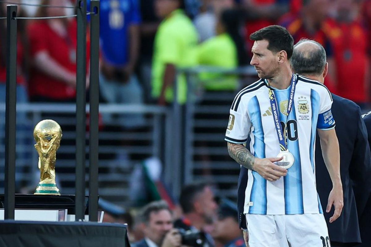 Argentina's forward #10 Lionel Messi looks at the trophy after losing the 2026 World Cup football tournament final match between Spain and Argentina at the New York/New Jersey Stadium in East Rutherford on July 19, 2026. PATRICIA DE MELO MOREIRA / AFP