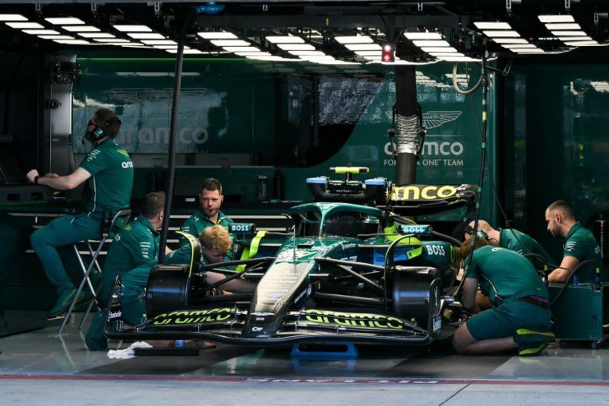 Aston Martin crew members work on the car of Aston Martin's Spanish driver Fernando Alonso ahead of the practice session for the United States Formula One Grand Prix at the Circuit of the Americas in Austin, Texas, on October 17, 2025. RONALDO SCHEMIDT / AFP