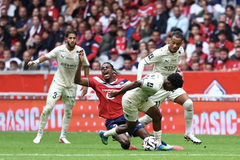 Lille's Belgian defender #03 Nathan Ngoy (2L) and Troyes' Togolese midfielder #29 Dermane Karim (2R) fight for the ball during the French L1 football match between Lille (LOSC) and Troyes (ESTAC) at the Stade Pierre-Mauroy in Villeneuve-d'Ascq on September 13, 2026. Sameer AL-DOUMY / AFP