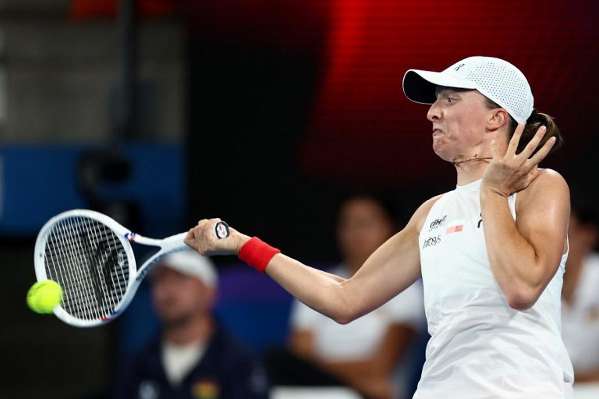 Poland's Iga Swiatek hits a return to Germany's Eva Lys during their women's singles match at the United Cup tennis tournament on Ken Rosewood Arena in Sydney on January 5, 2026. Izhar KHAN / AFP