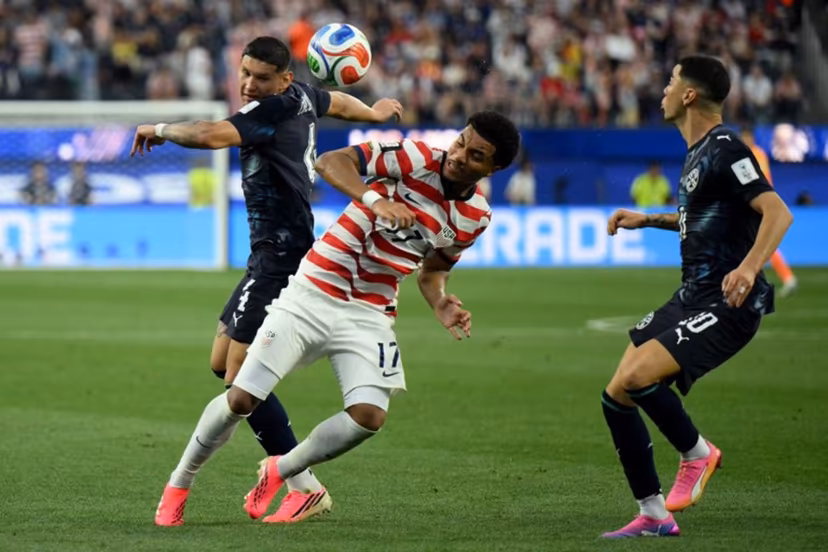 Paraguay's defender #04 Juan Jose Caceres (L) and US midfielder #17 Malik Tillman (C) fight for the ball during the 2026 World Cup Group D football match between USA and Paraguay at the Los Angeles Stadium in Inglewood on June 12, 2026. Patrick T. Fallon / AFP