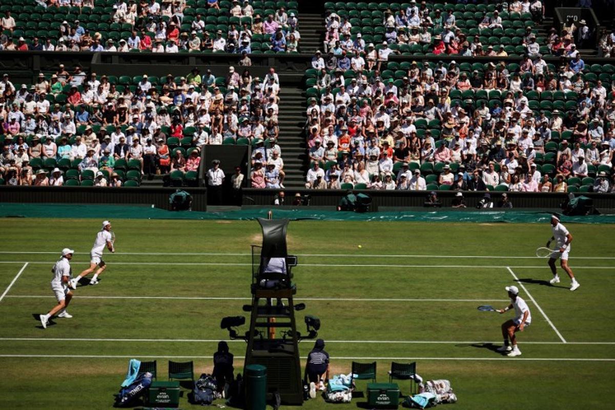 Australia's Rinky Hijikata playing with Netherlands' David Pel (R) return the ball to Britain's Julian Cash and Britain's Lloyd Glasspool (L) during their men's doubles final tennis match on the thirteenth day of the 2025 Wimbledon Championships at The All England Lawn Tennis and Croquet Club in Wimbledon, southwest London, on July 12, 2025. HENRY NICHOLLS / AFP
