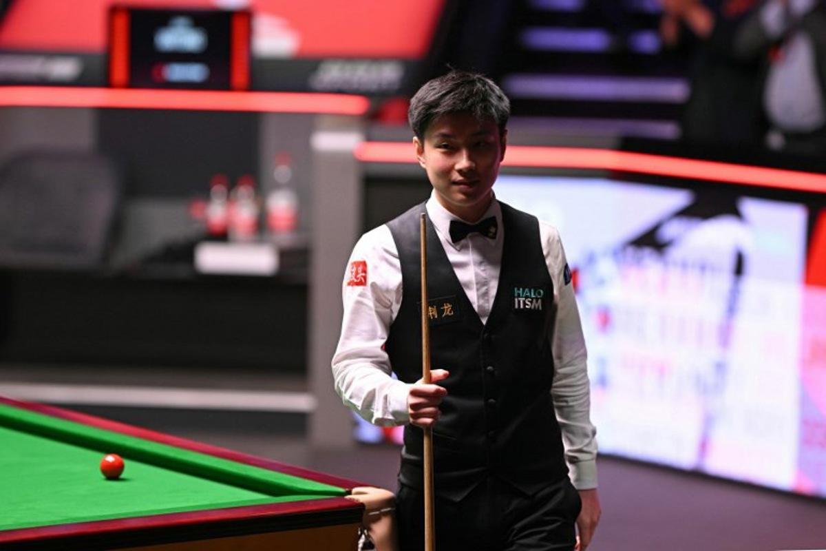 China's Zhao Xintong reacts having lost the first four frames of the final session, on day two of his World Championship Snooker final against Wales' Mark Williams at The Crucible in Sheffield, northern England on May 5, 2025. Oli SCARFF / AFP