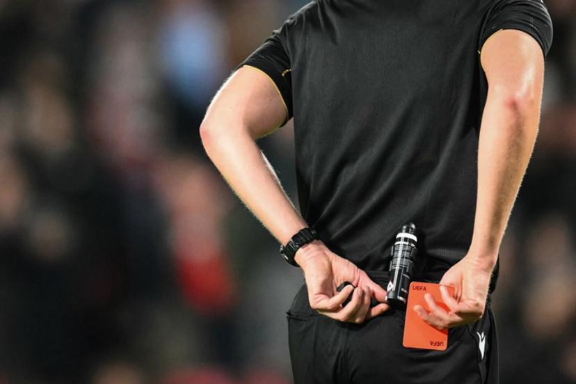 Referee Daniel Siebert puts back in his pocket the red card after showing it to Napoli's Italian forward #27 Lorenzo Lucca during the UEFA Champions League, league phase football match between PSV Eindhoven and Napoli at the Philips Stadium, in Eindhoven, on October 21, 2025.  NICOLAS TUCAT / AFP