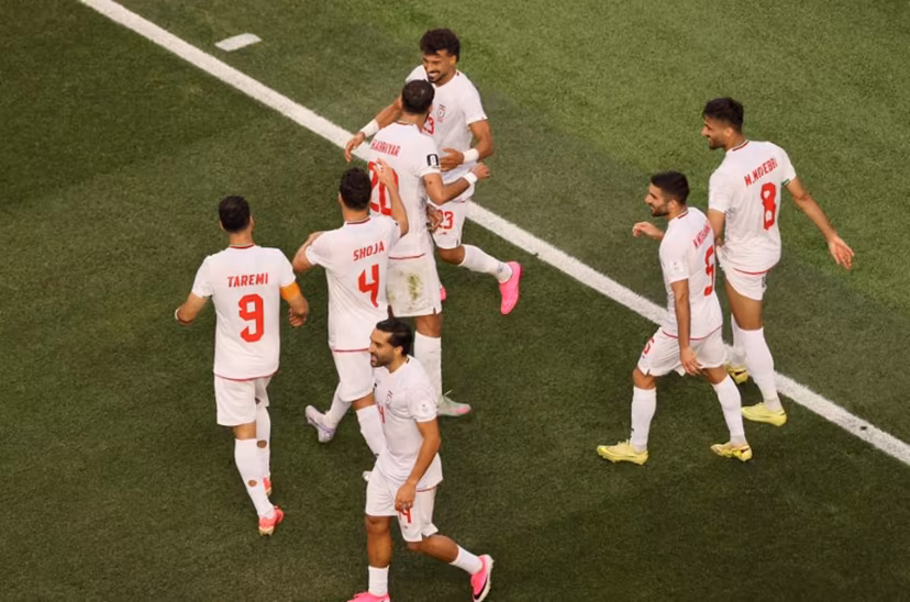 Iran's defender #23 Ramin Rezaeian celebrates with teammates after scoring his team's first goal during the 2026 World Cup Group G football match between Iran and New Zealand at Los Angeles Stadium in Inglewood on June 15, 2026. Etienne Laurent / AFP