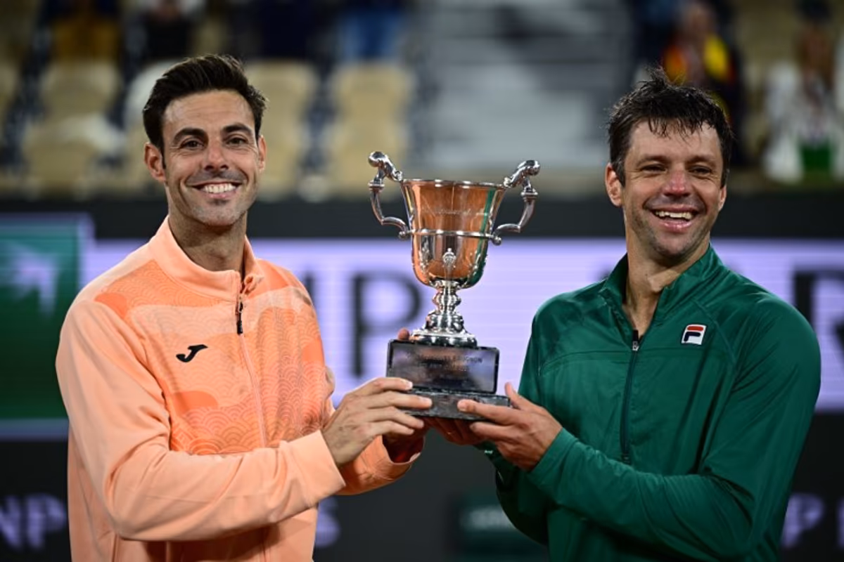 Spain's Marcel Granollers (L) and Argentina's Horacio Zeballos hold their trophy after winning their men's doubles final match against Britain's Joe Salisbury and Britain's Neal Skupski on day 14 of the French Open tennis tournament on Court Philippe-Chatrier at the Roland-Garros Complex in Paris on June 7, 2025. JULIEN DE ROSA / AFP