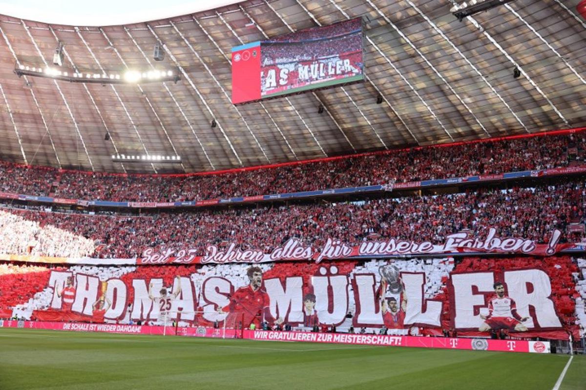 Fans display banner depicting outgoing Bayern Munich's German forward #25 Thomas Mueller ahead the German first division Bundesliga football match between Bayern Munich and Borussia Moenchengladbach in Munich on May 10, 2025. Alexandra BEIER / AFP