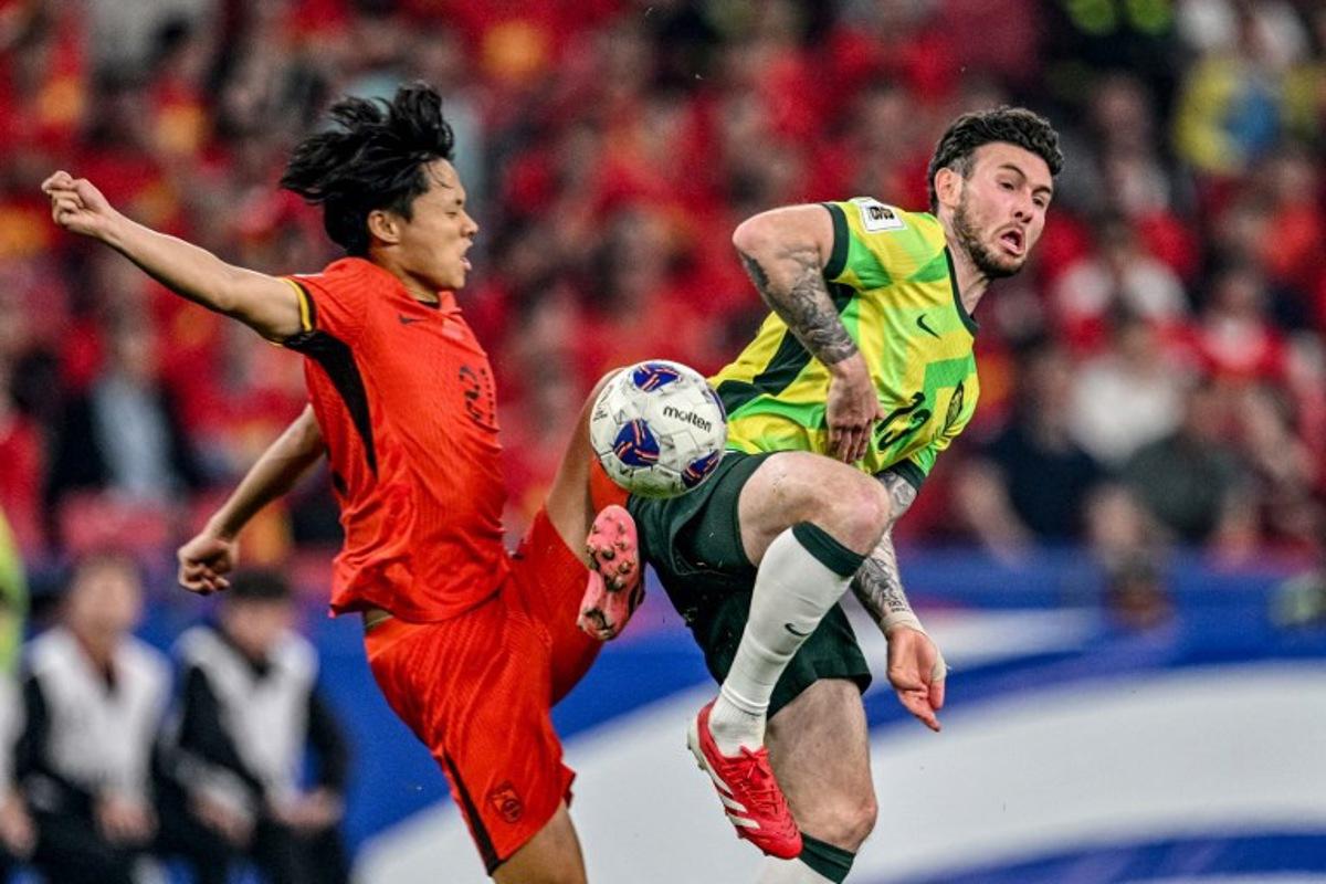 China's Wang Haijian (L) competes for the ball with Australia's Aiden O'Neill (Center, R) during the 2026 FIFA World Cup qualification football match between China and Australia at the Hangzhou Olympic Sports Center Stadium in Hangzhou, in China's eastern Zhejiang province on March 25, 2025. Hector RETAMAL / AFP