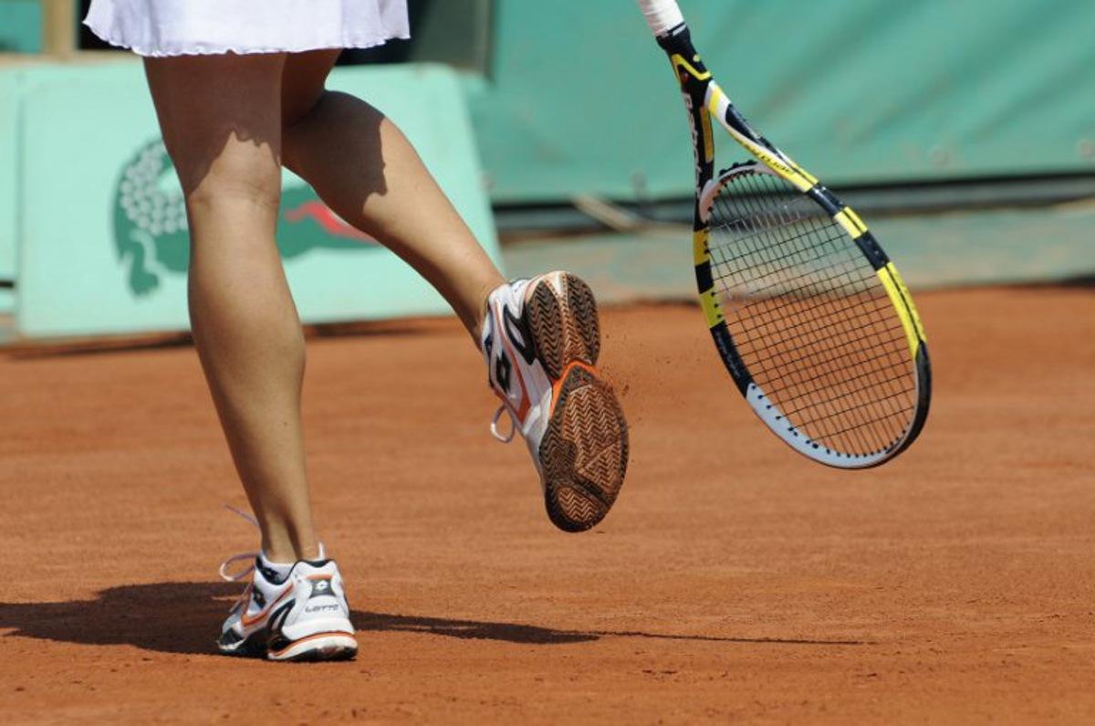 Italy's Francesca Schiavone knocks clay from the tread of her shoes as she prepares to serve against Australia's Samantha Stosur during their women's final match in the French Open tennis championship at the Roland Garros stadium, on June 5, 2010, in Paris. AFP PHOTO/BORIS HORVAT BORIS HORVAT / AFP