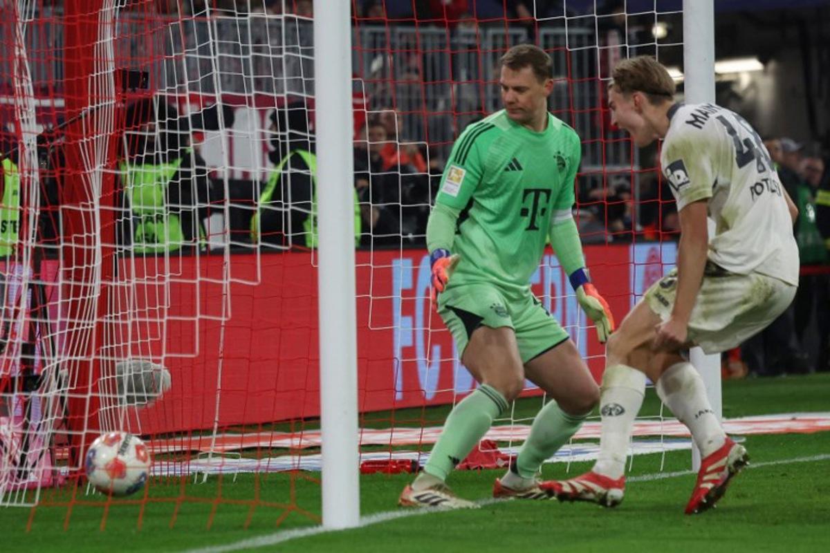 Mainz' Polish defender #48 Kacper Potulski (R) scores the 1-1 goal past Bayern Munich's German goalkeeper #01 Manuel Neuer during the German first division Bundesliga football match between FC Bayern Munich and Mainz 05 in Munich, southern Germany on December 14, 2025. Karl-Josef HILDENBRAND / AFP