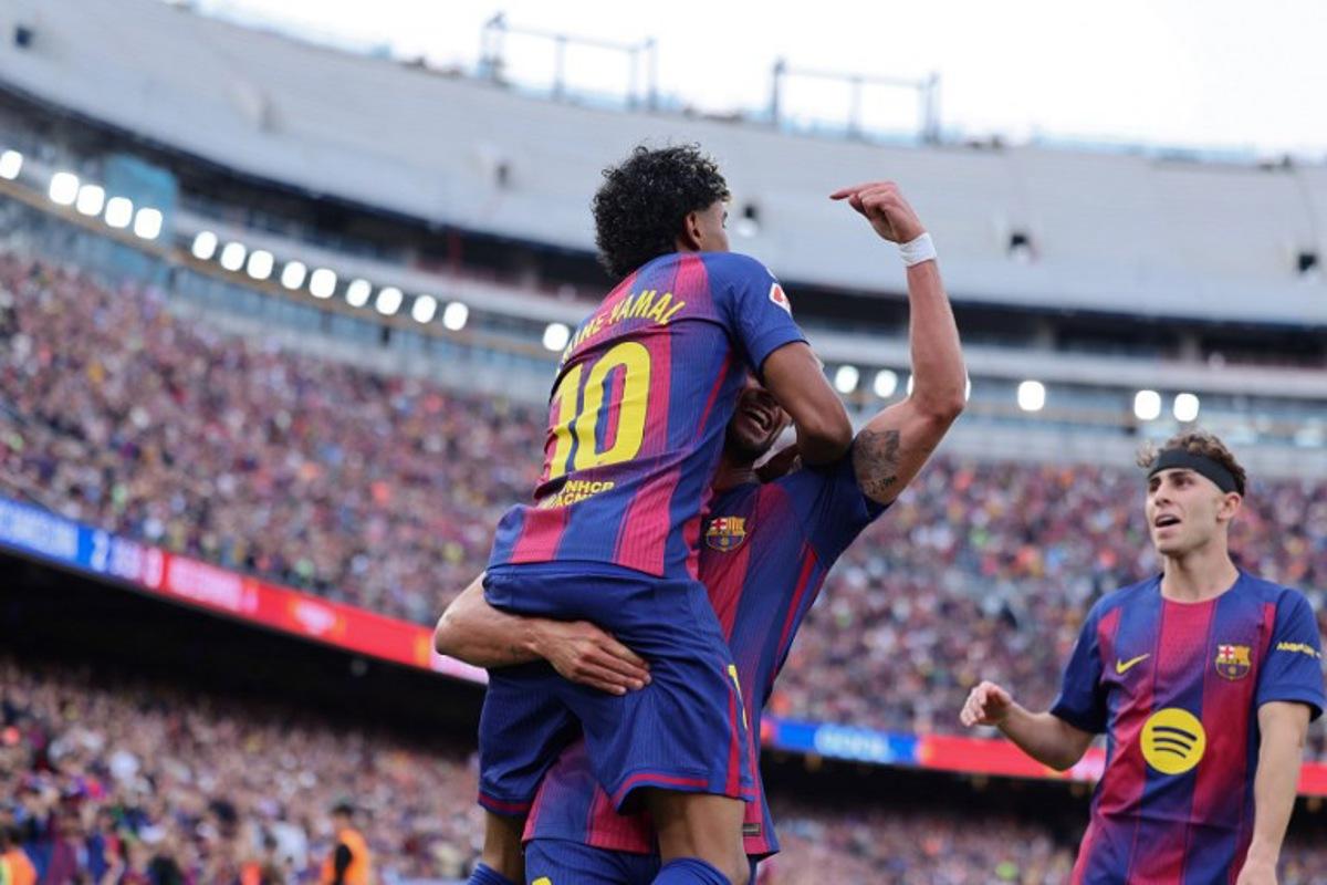 Barcelona's Spanish forward #07 Ferran Torres celebrates with Barcelona's Spanish forward #10 Lamine Yamal scoring his team's second goal during the Spanish league football match between FC Barcelona and RCD Espanyol at the Camp Nou stadium in Barcelona on April 11 , 2026. Josep LAGO / AFP