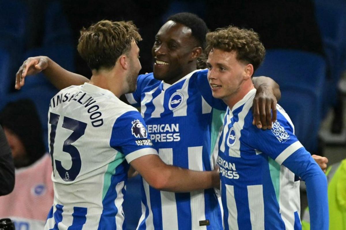 Brighton's English striker #18 Danny Welbeck (C) celebrates with Brighton's English midfielder #13 Jack Hinshelwood (L) and Brighton's Belgian defender #29 Maxim De Cuyper (R) after scoring their third goal during the English Premier League football match between Brighton and Hove Albion and Chelsea at the American Express Community Stadium in Brighton, southern England on April 21, 2026. Glyn KIRK / AFP