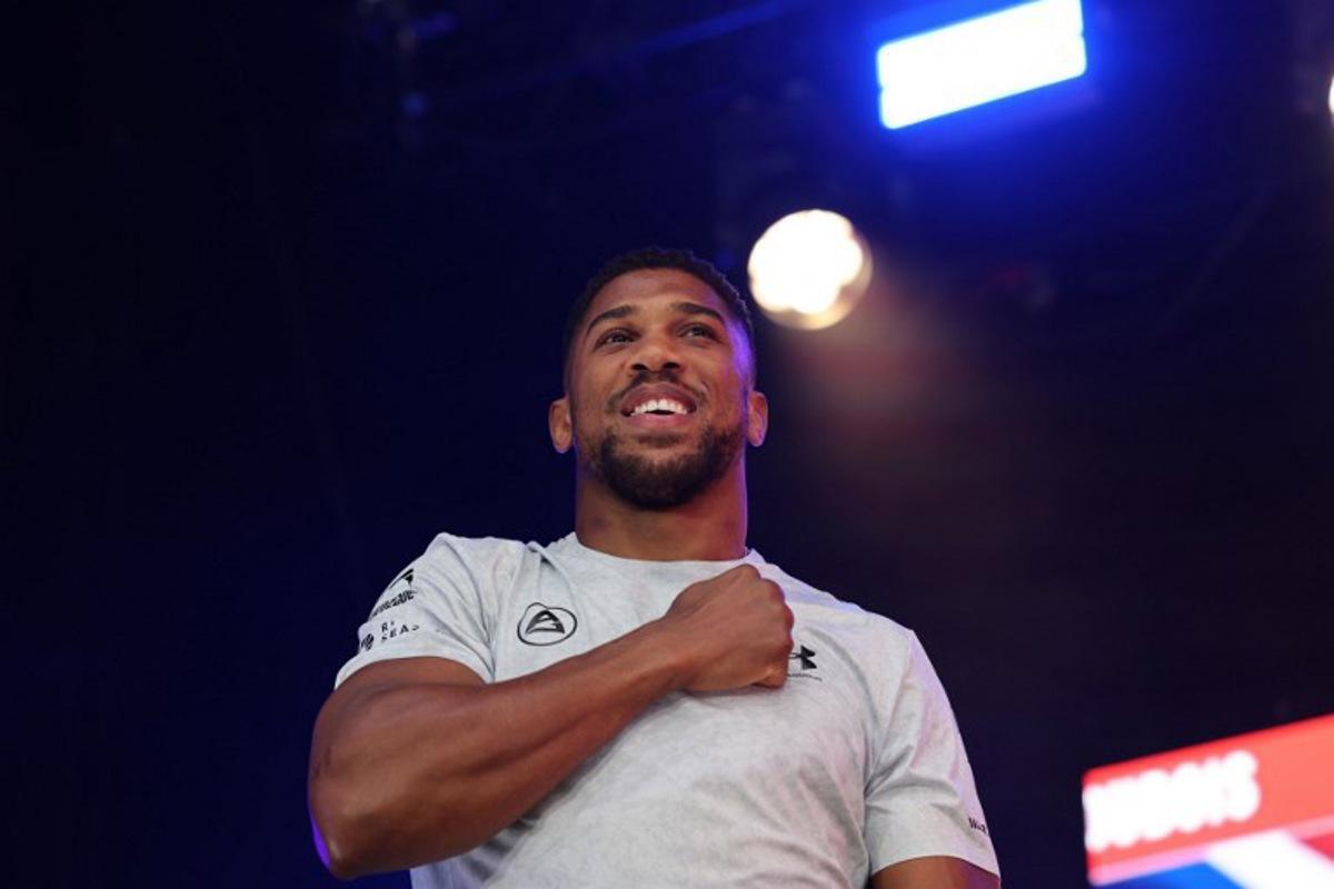 Britain's Anthony Joshua gestures as he arrives on stage for a public weigh-in in Trafalgar Square on September 20, 2024 on the eve of a heavyweight boxing match for the IBF world title in London. Daniel Dubois says he has to justify his status as IBF world heavyweight champion by showing he is the coming force in British boxing against Anthony Joshua at a sold-out Wembley on Saturday. The pair will battle it out in front of a reported post-war British record crowd of 96,000. Dubois won the interim IBF title in June and was elevated to world champion status when Oleksandr Usyk vacated. Adrian Dennis / AFP
