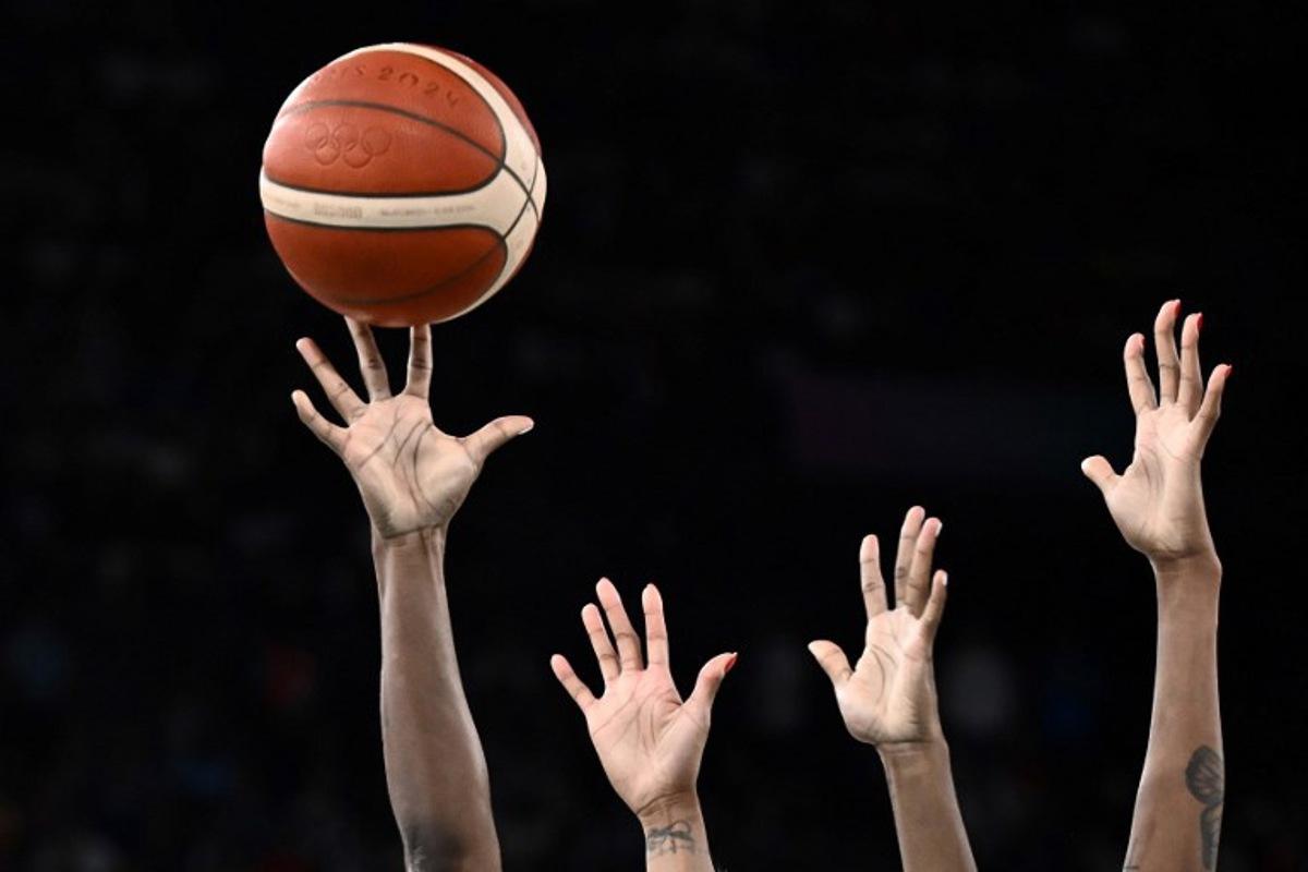 USA's #13 Jackie Young (L) and France's #11 Valeriane Ayayi go for a rebound in the women's Gold Medal basketball match between France and the USA during the Paris 2024 Olympic Games at the Bercy Arena in Paris on August 11, 2024. Aris MESSINIS / AFP